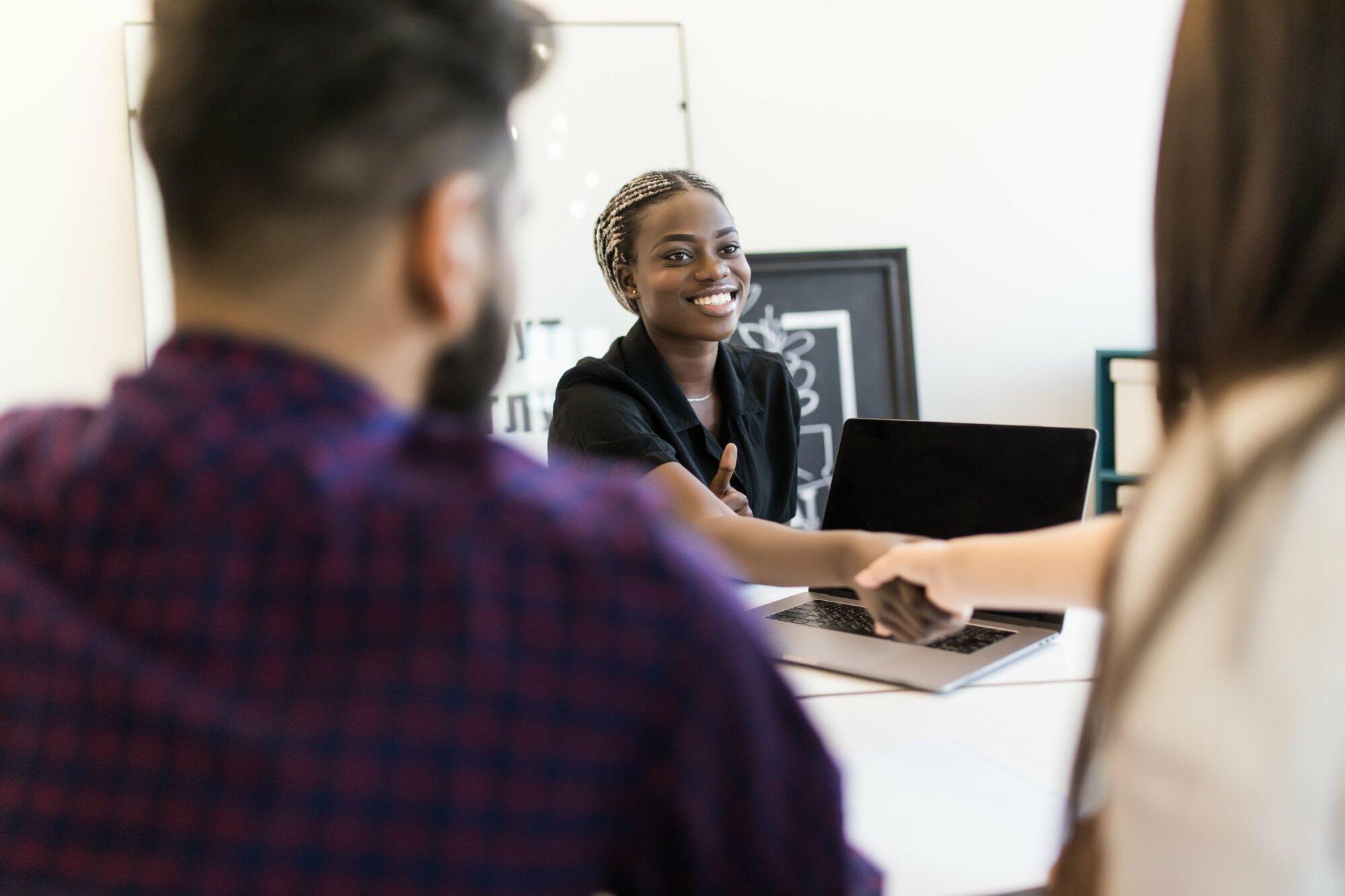 African american hr team welcoming female applicant at job interview, diverse businesswomen shaking hands at multi ethnic group meeting, handshaking and good first impression, teamwork introduction
