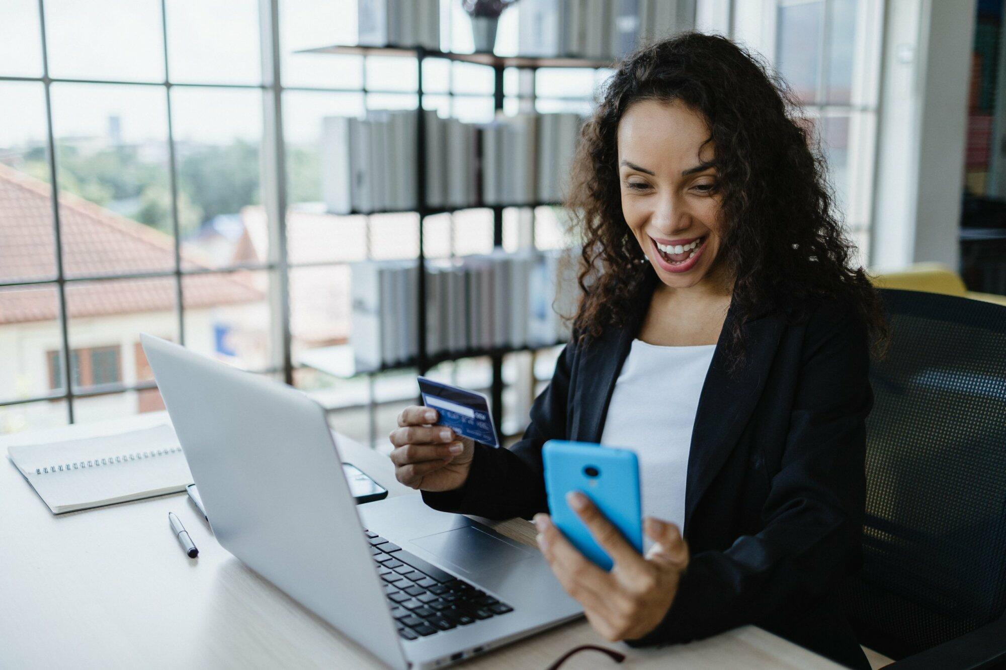 Young woman using laptop and smartphone shopping online by payin